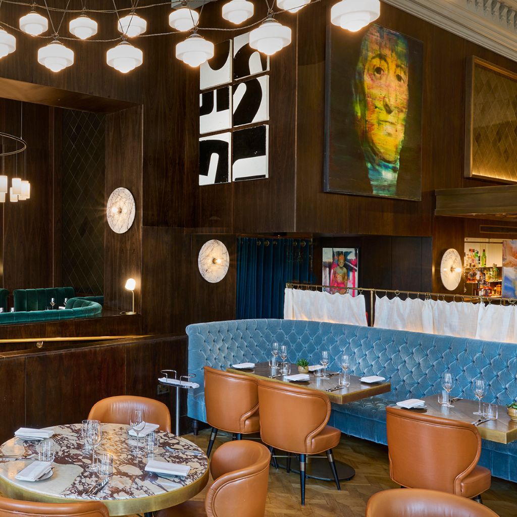 Wild Honey restaurant Christmas Eve dining room with orange chairs, blue tufted banquette and contemporary art